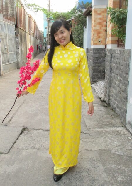 Áo dài gấm đồng tiền màu vàng
