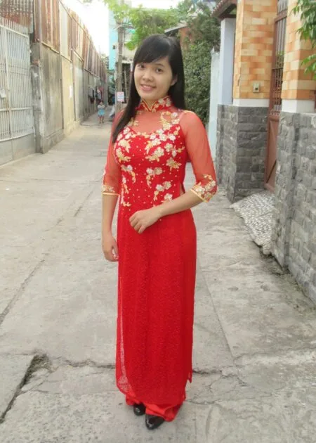 Áo dài lưới đỏ kết đá, hoa vàng